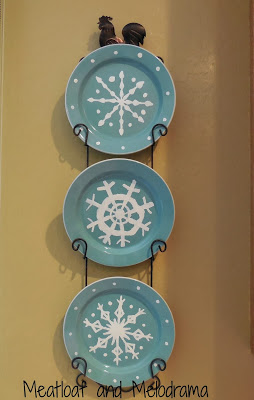 hand-painted snowflake plates in plate holder, blue and white plates