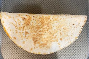 crispy folded tortilla on griddle