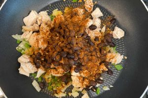 chicken, black beans, jalapeno pepper and onions with taco seasoning in skillet