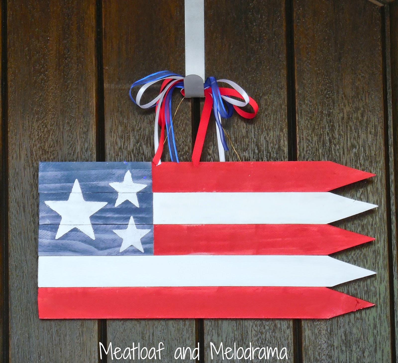 wooden American flag with red, white and blue ribbons