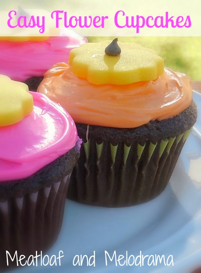 chocolate cupcakes with pink and yellow frosting and fondant flowers