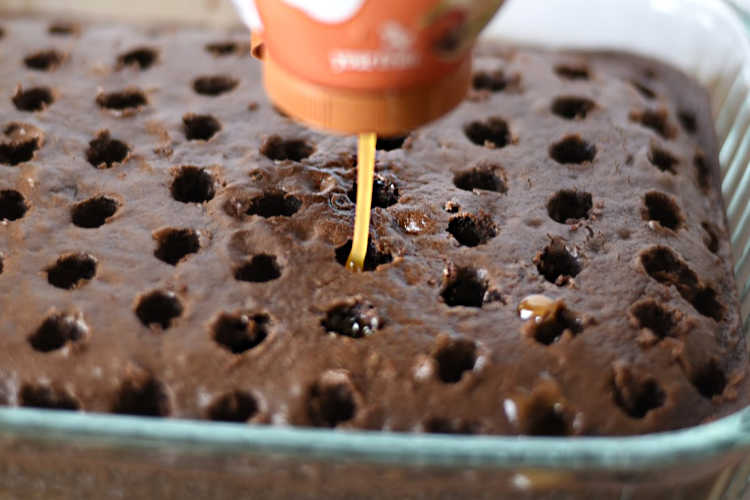 pour caramel syrup into chocolate poke cake