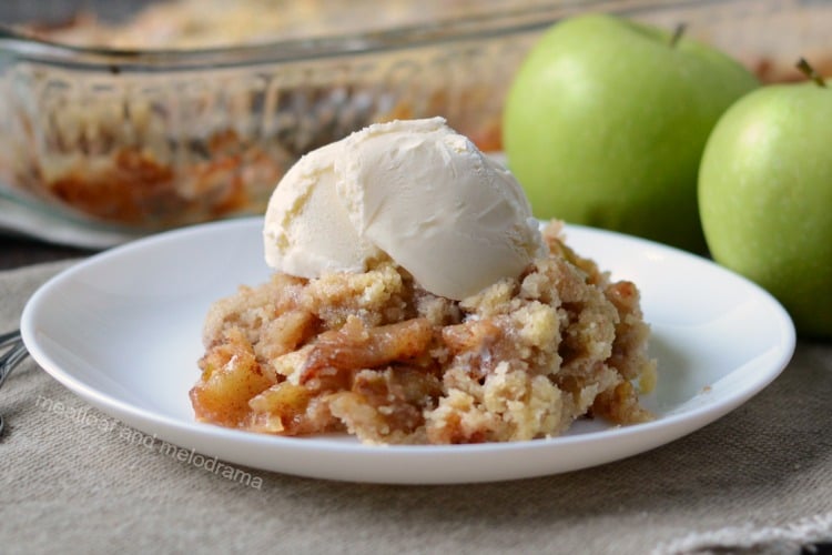 cinnamon apple crisp on a white plate with vanilla ice cream