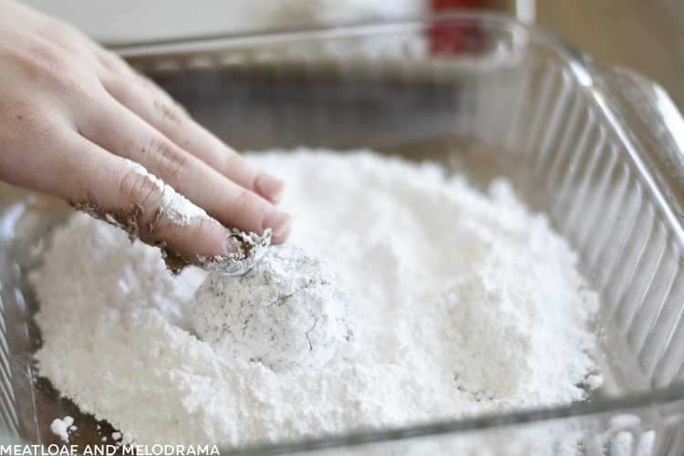 roll chocolate crinkle cookie dough in powdered sugar