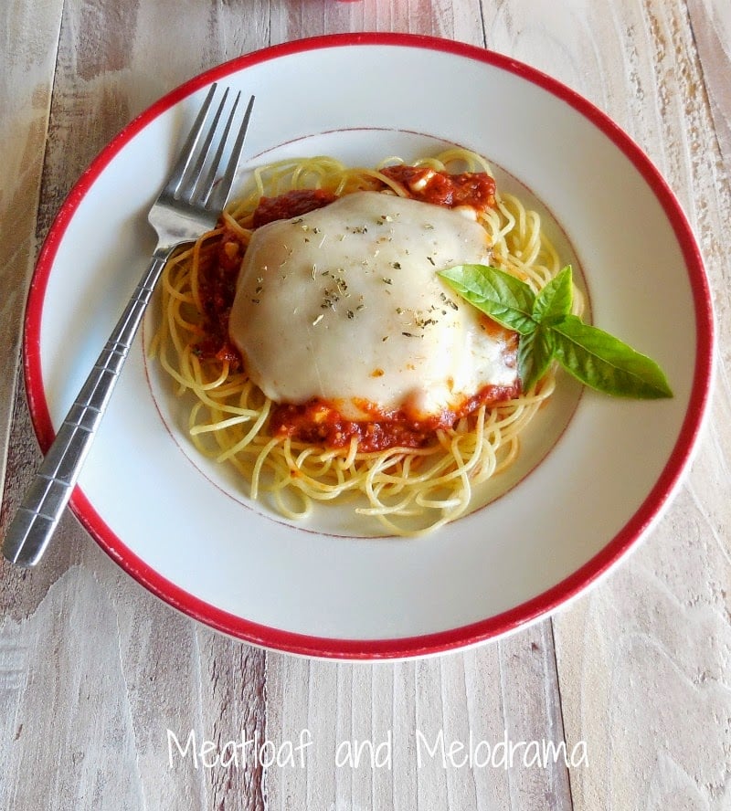 chicken parm with melted cheese on spaghetti