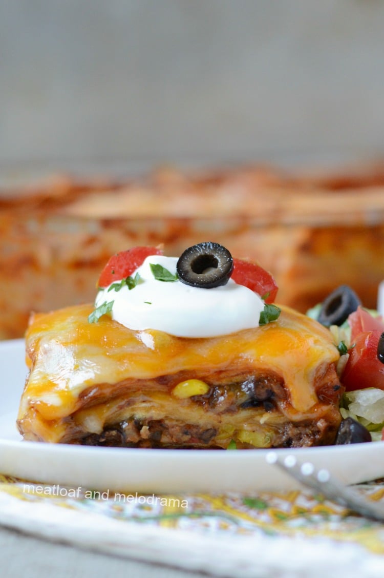 southwestern lasagna enchilada casserole topped with sour cream