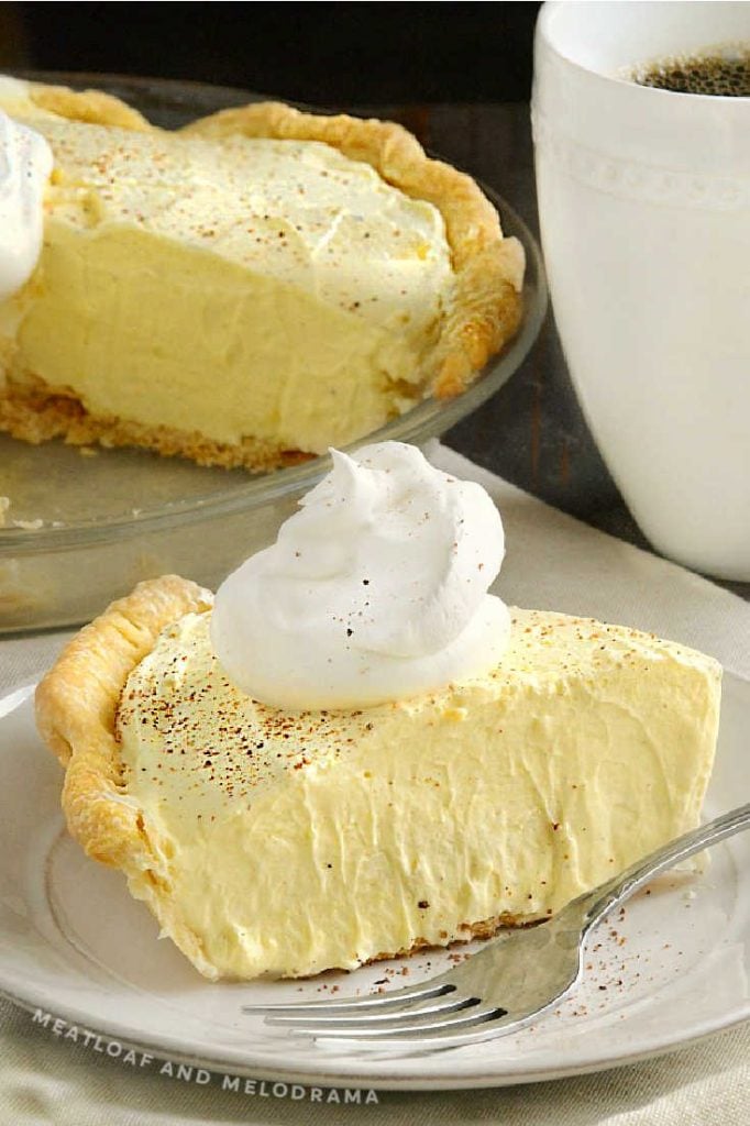 slice of eggnog pie with whipped topping and pie in backgraound