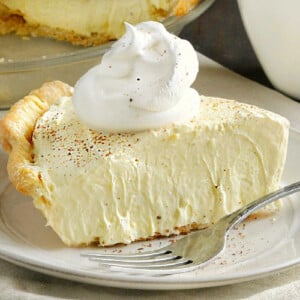 slice of eggnog pie on a plate with cool whip