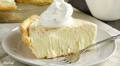 slice of eggnog pie on a plate with cool whip