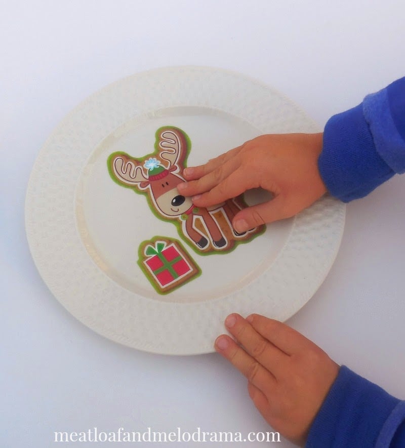 boy putting reindeer window cling on plate