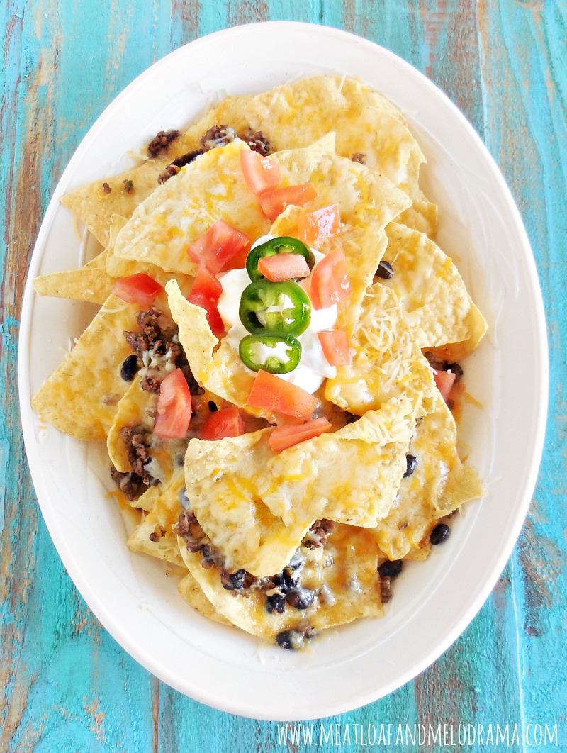 easy loaded baked nacho platter with beef and tomatoes and sour cream