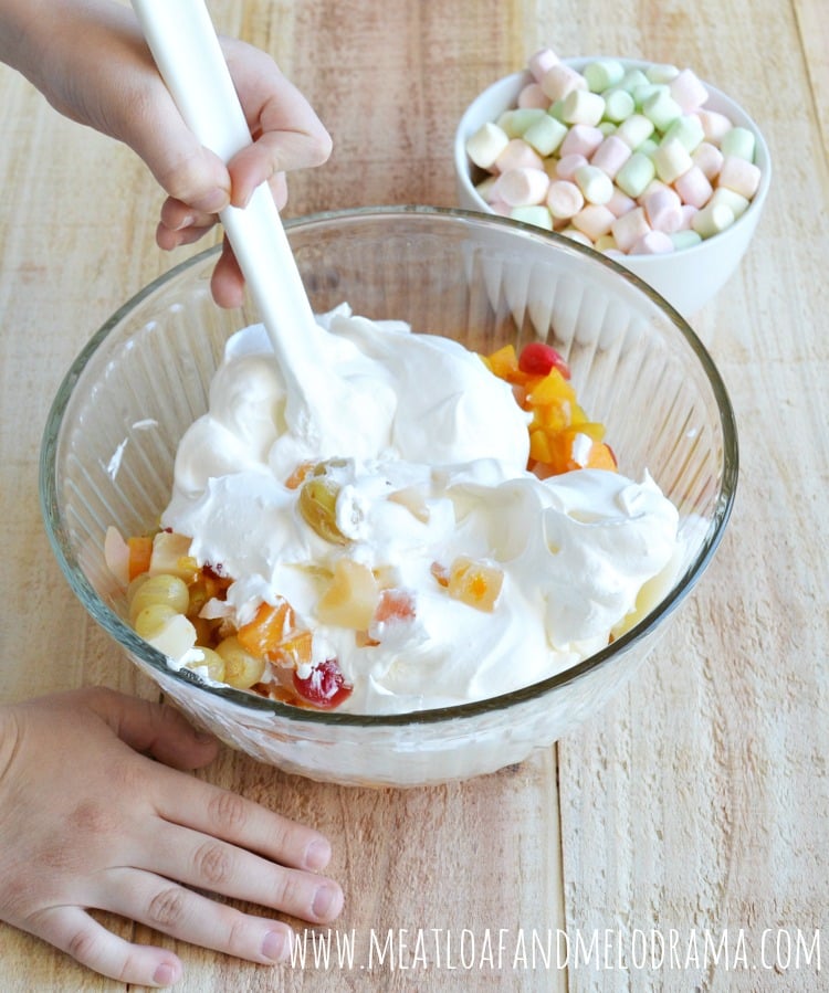 pour canned mixed fruit in a bowl with cool whip