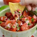 spicy pico de gallo in a green bowl with tortilla chips