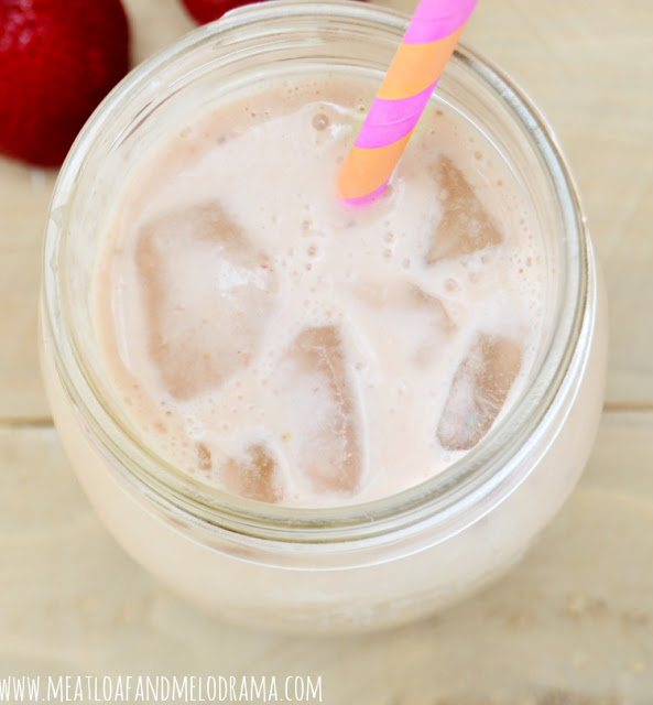 fruity breakfast smoothie in a mason jar with ice and straw