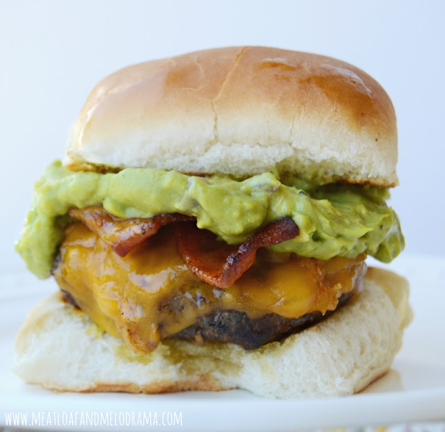 bacon cheddar cheeseburger topped with guacamole on a toasted bun
