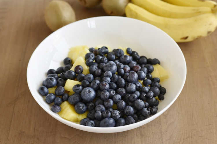 blueberries and pineapple chunks in white bowl