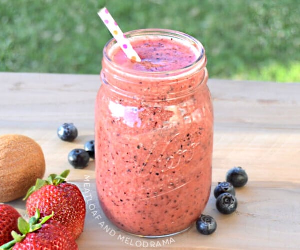 summer fruit smoothie in a mason jar with strawberries blueberries and kiwi fruit