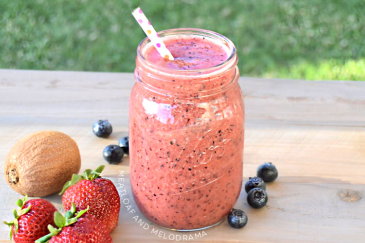 summer fruit smoothie in a mason jar with strawberries blueberries and kiwi fruit