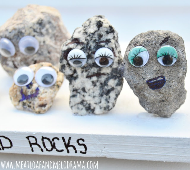 rocks with faces on wood board