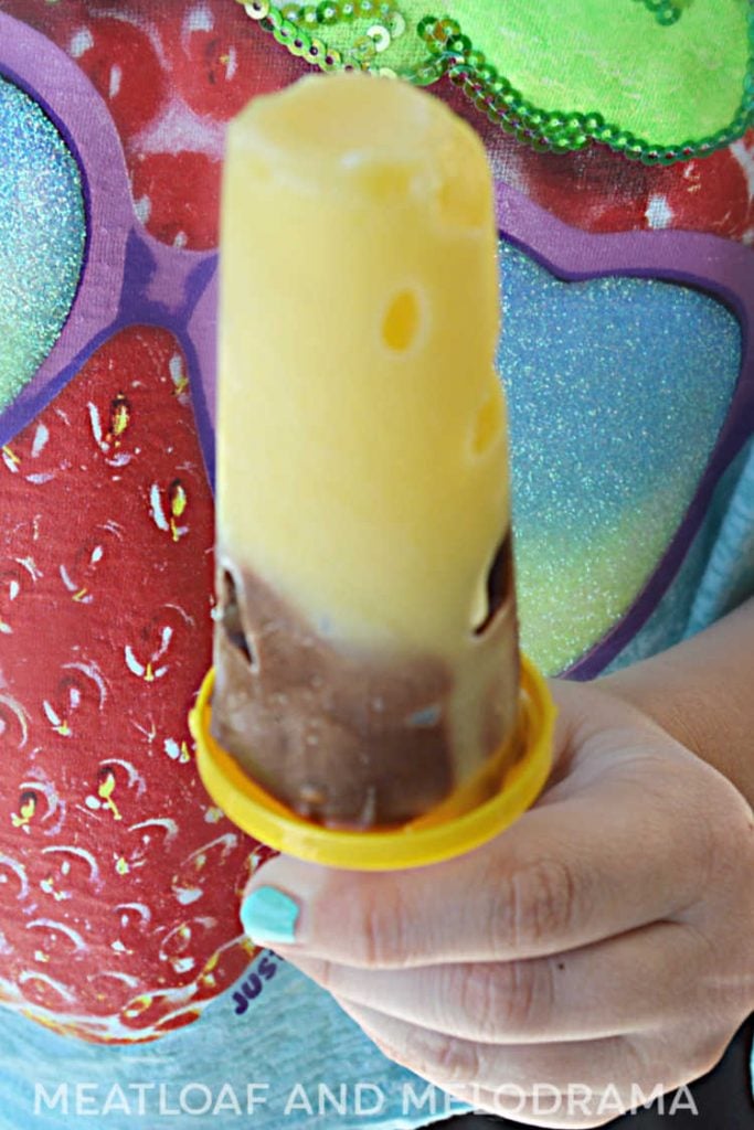 girl holding frozen vanilla chocolate jello pudding pop