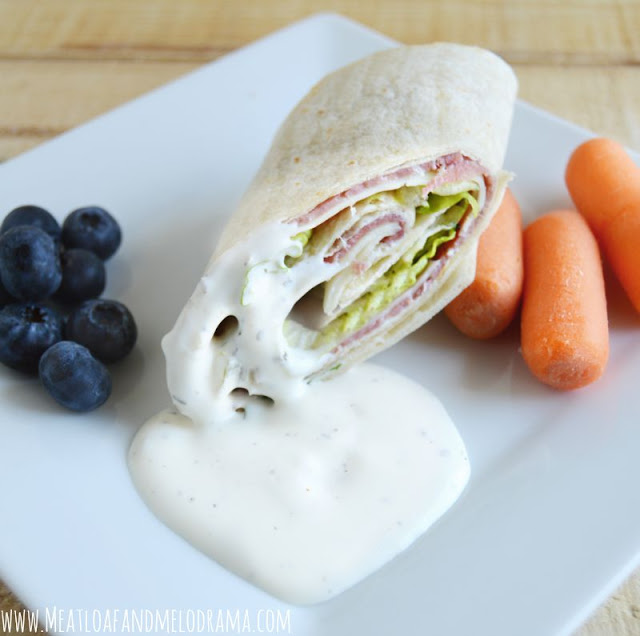 sandwich wraps with buttermilk dressing served with blueberries and raw carrots