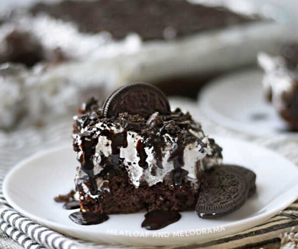 oreo poke cake with oreo cookies on white plate