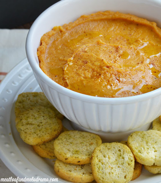 bowl of pumpkin hummus and toasted mini bread rounds