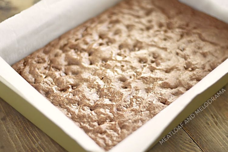 brownies baked in a metal pan with parchment paper