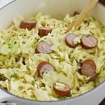 haluski and kielbasa, fried cabbage with noodles and smoked sausage in a white dutch oven