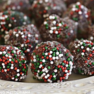 bourbon balls rolled in red and green candy sprinkles on a plate