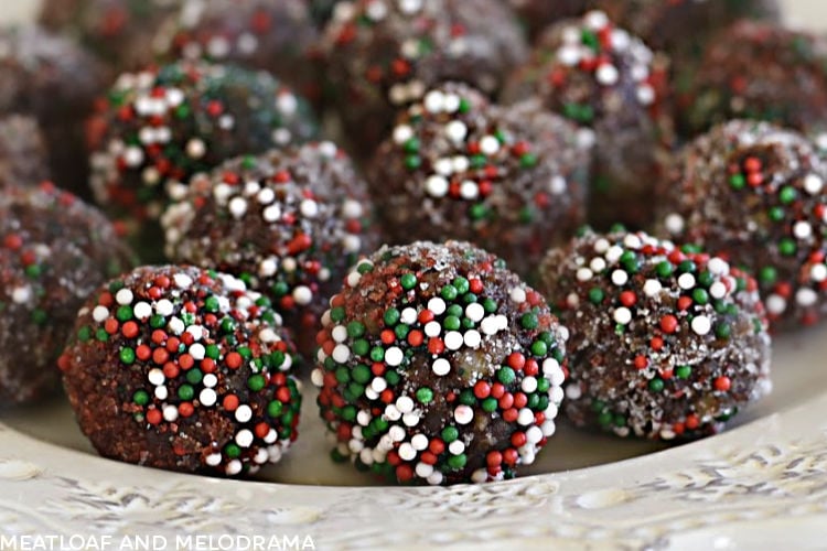 bourbon balls rolled in red and green candy sprinkles on a plate