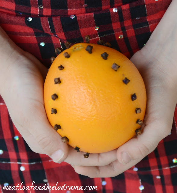 girl-holding-clove-studded-orange-pomander