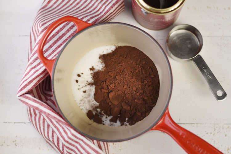 sugar and cocoa powder for homemade hot cocoa in red pot
