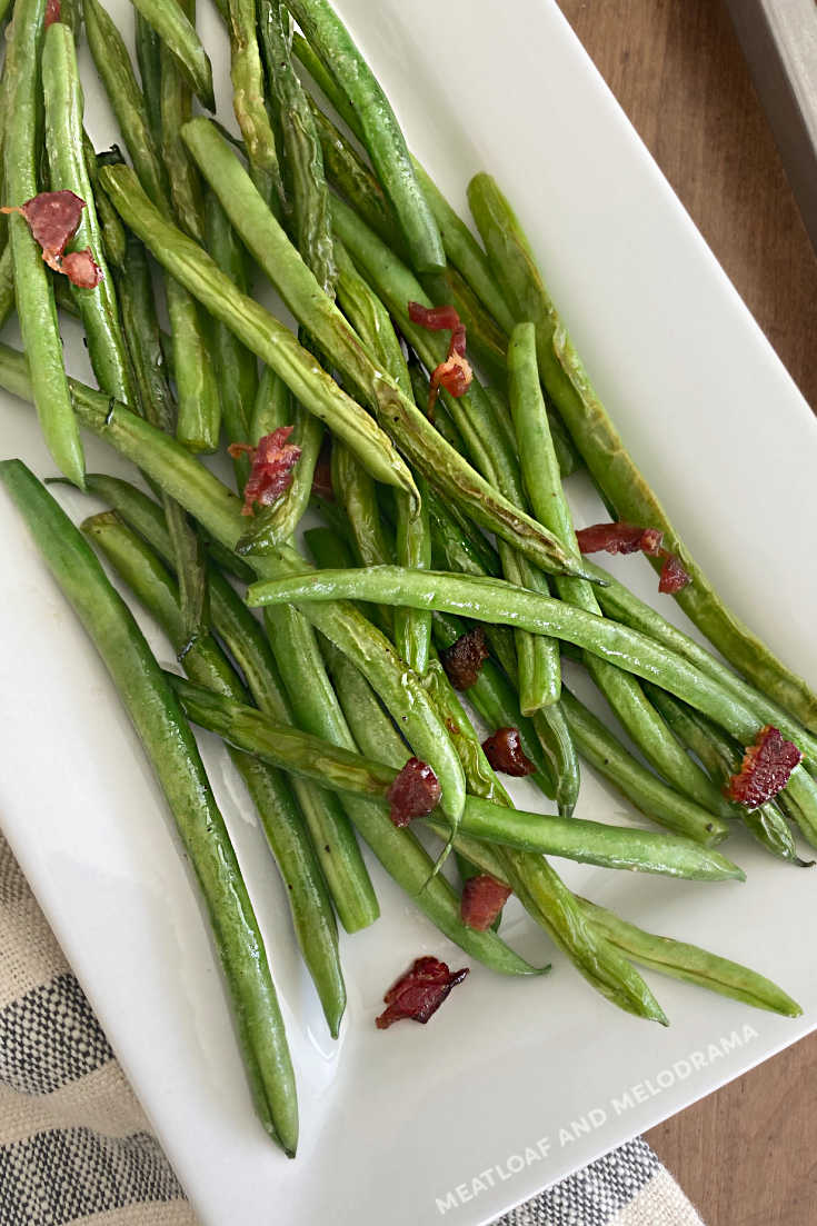 easy sauteed green beans with bacon and parmesan cheese on platter