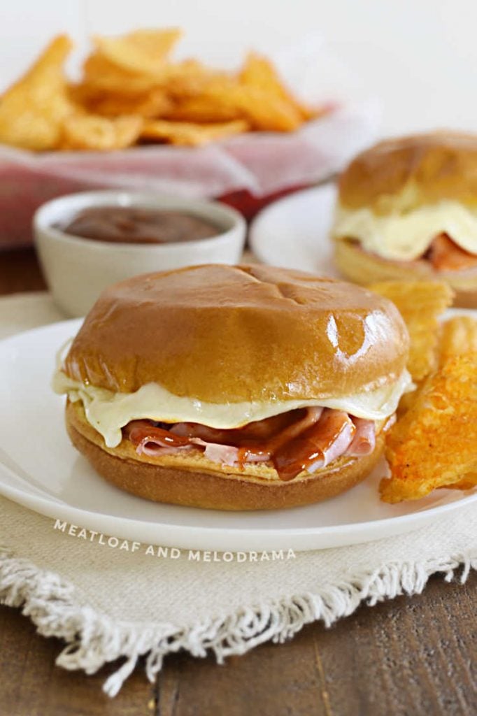 hot ham and provolone cheese sliders with bbq sauce on a plate