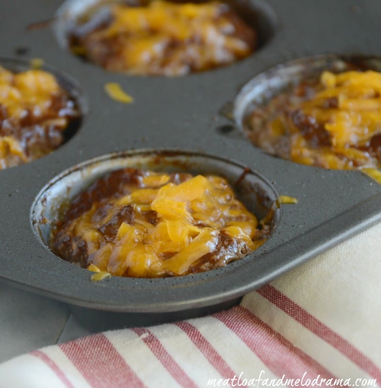 mini meatloaf muffins with bbq sauce and cheddar cheese in muffin tin 