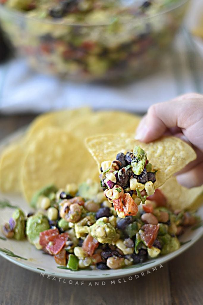 cowboy caviar on a tortilla chip in hands