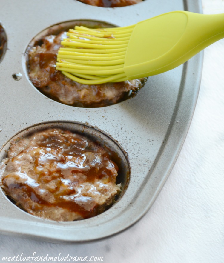brush bbq sauce on mini meatloaf muffins in muffin tin