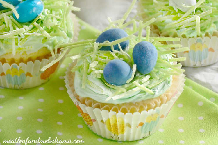 easter cupcakes topped with edible grass and chocolate candy eggs in a nest