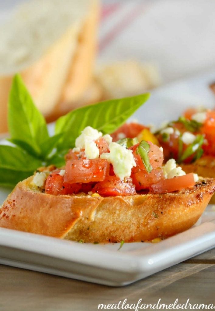 toasted bread topped with tomatoes, gorgonzola cheese and basil
