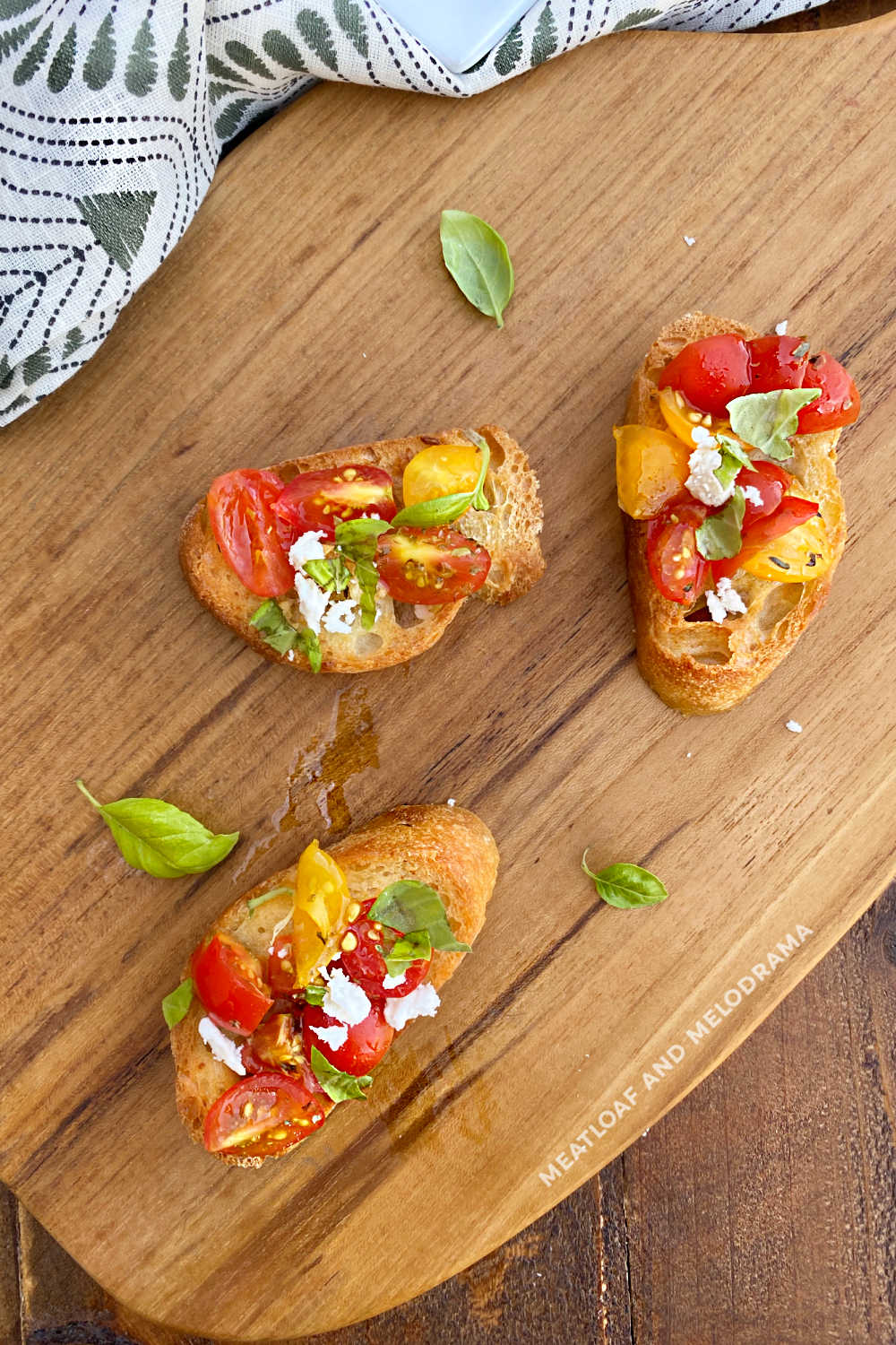 bruschetta with yellow and red cherry tomatoes and basil on a cutting board