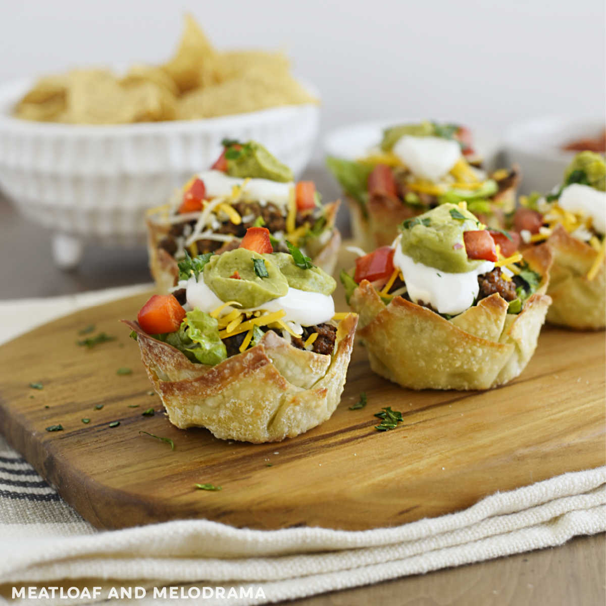 mini taco salad cups on a wood serving board