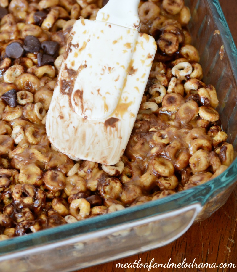 spread chocolate, peanut butter and cheerios in baking dish