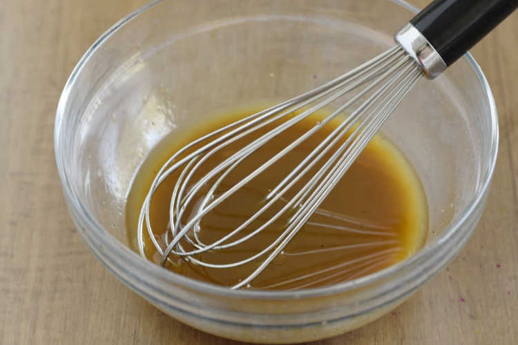 whisk Asian salad dressing in mixing bowl