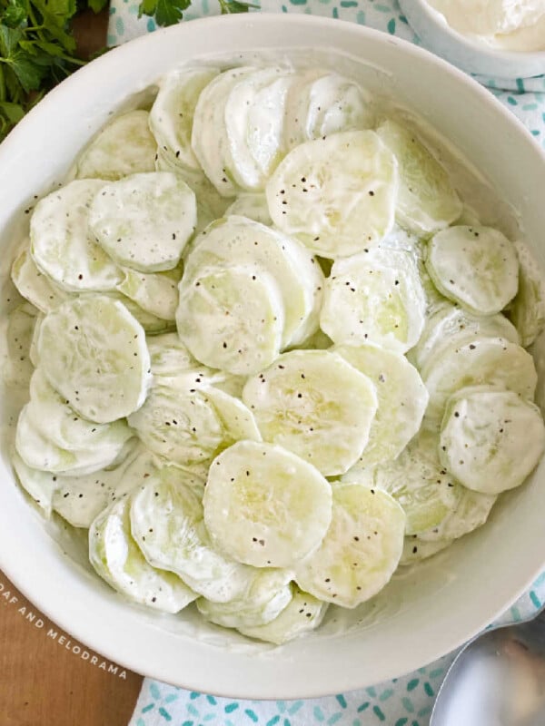 creamy cucumber salad with sour cream in a white serving bowl