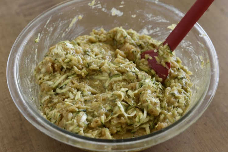 grated zucchini and bread batter in mixing bowl