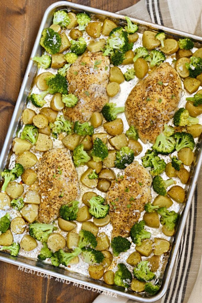 baked chicken and potatoes with broccoli on a sheet pan