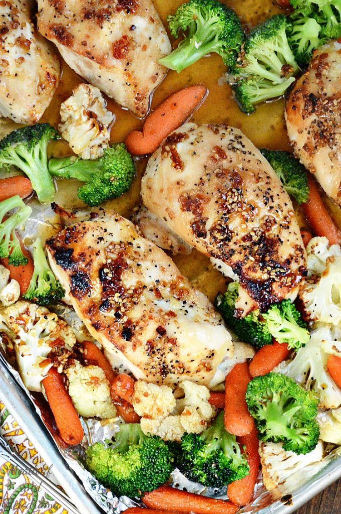 chicken breasts and vegetables with teriyaki sauce on a baking sheet 