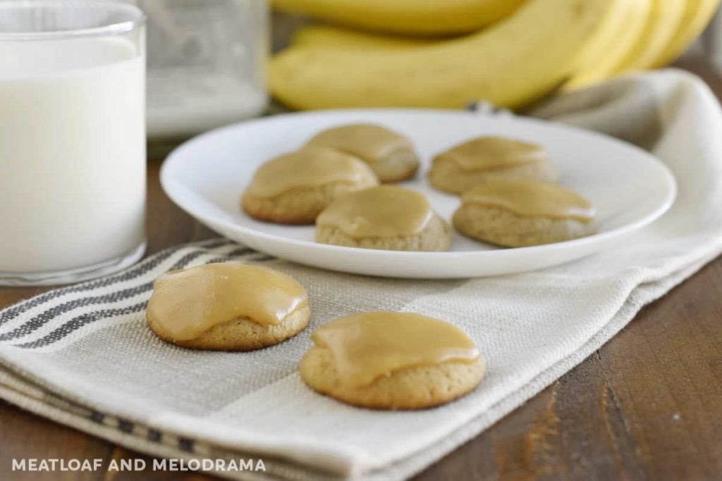 banana bread cookies with brown sugar frosting on a table with milk