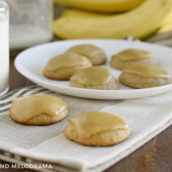 banana bread cookies with brown sugar frosting on a table with milk